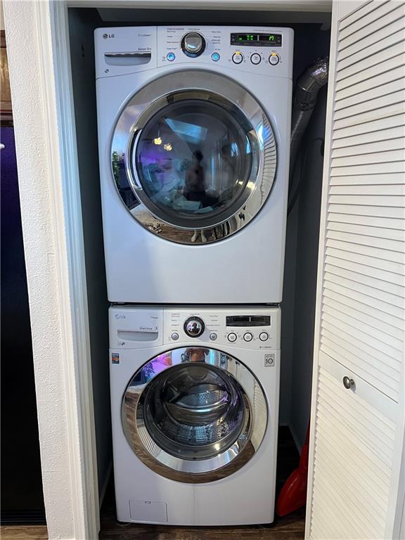 2201 Houma Blvd Unit 303, Metairie, LA 70001 - washroom with stacked washing machine and dryer and wood finished floors
