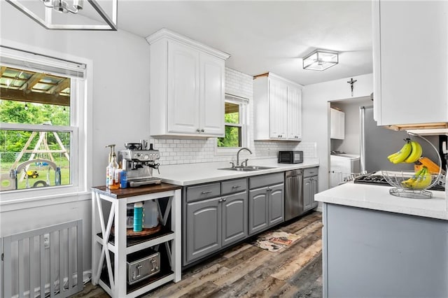 326 Barton Ave, Luling, LA 70070 - kitchen featuring a sink, gray cabinetry, dishwasher, tasteful backsplash, and separate washer and dryer
