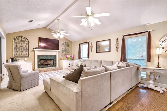 21360 Stire St, Abita Springs, LA 70420 - living room featuring a ceiling fan, a fireplace with raised hearth, a textured ceiling, and wood finished floors
