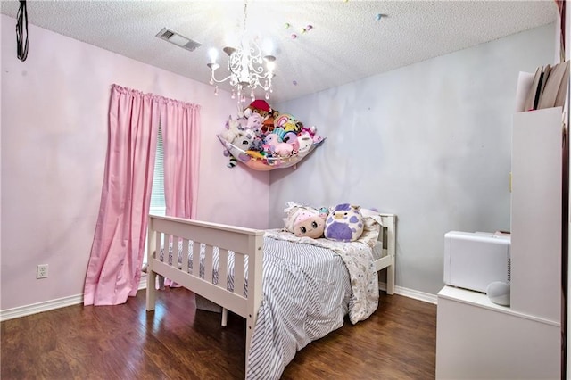21360 Stire St, Abita Springs, LA 70420 - bedroom featuring a chandelier, wood finished floors, baseboards, and a textured ceiling
