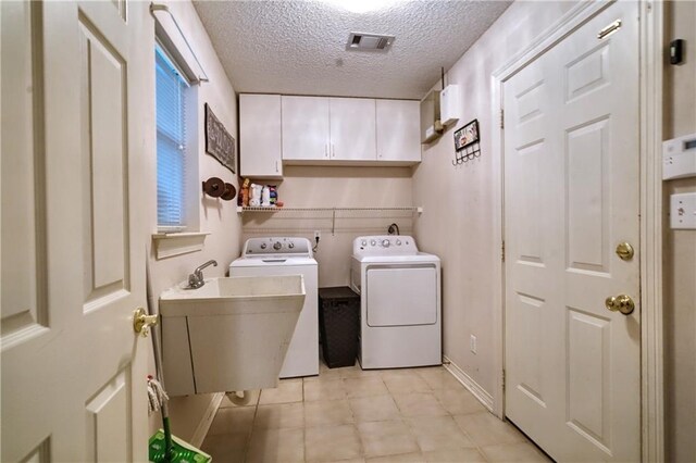 21360 Stire St, Abita Springs, LA 70420 - washroom featuring washer and clothes dryer, cabinet space, a textured ceiling, and light tile patterned floors
