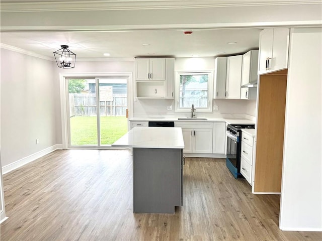 3805 Purdue Dr, Metairie, LA 70003 - kitchen featuring electric range, a sink, healthy amount of natural light, a center island, and ornamental molding