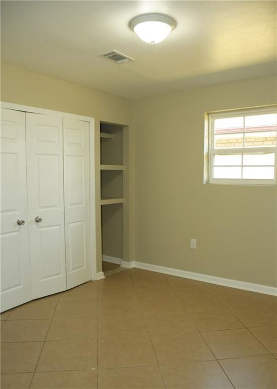 6 Marywood Ct, New Orleans, LA 70128 - unfurnished bedroom with light tile patterned floors, a closet, and baseboards