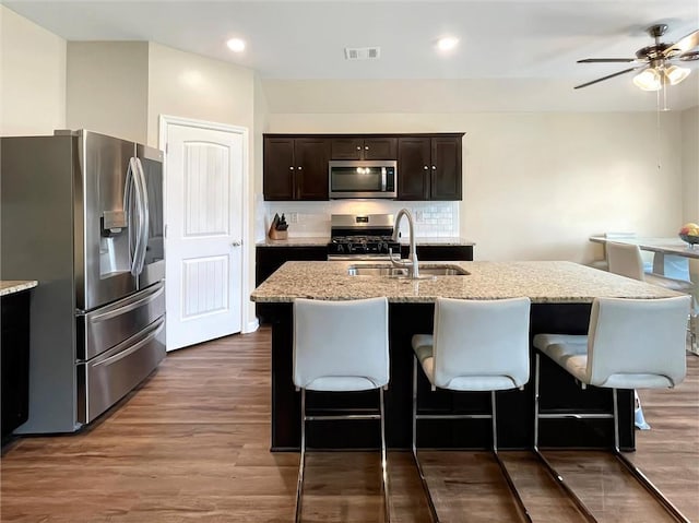 75616 Sylvia Dr, Covington, LA 70435 - kitchen with stainless steel appliances, a sink, ceiling fan, light stone counters, and a breakfast bar area