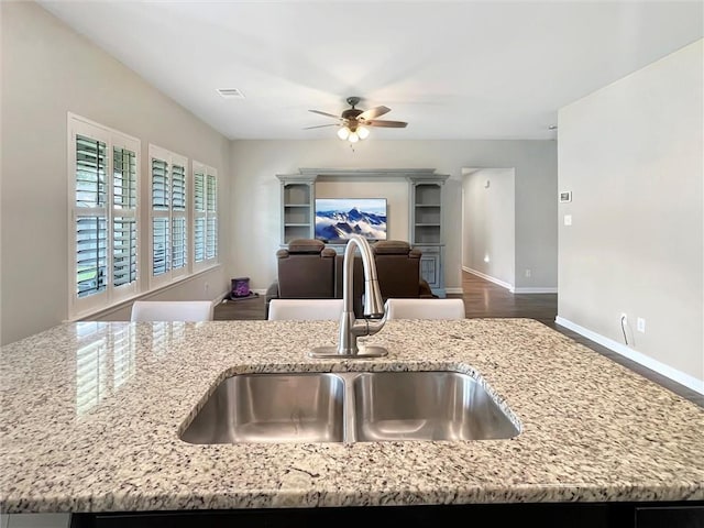 75616 Sylvia Dr, Covington, LA 70435 - kitchen with a sink, a ceiling fan, light stone countertops, open floor plan, and baseboards