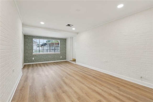 4912 Ithaca St, Metairie, LA 70006 - unfurnished room with brick wall, baseboards, wood finished floors, and recessed lighting