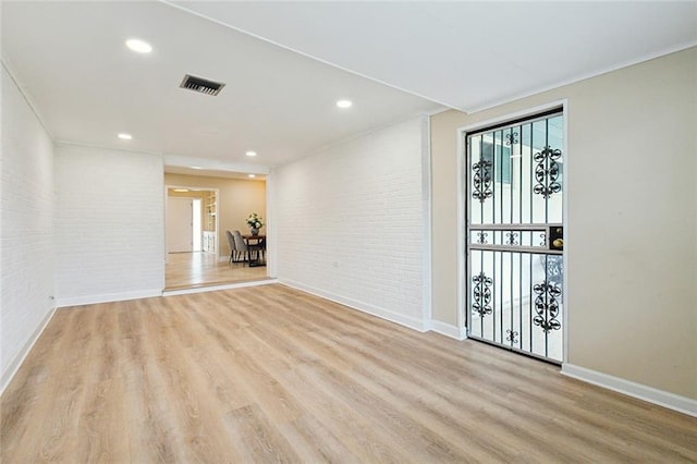 4912 Ithaca St, Metairie, LA 70006 - spare room featuring brick wall, light wood-style floors, baseboards, and recessed lighting
