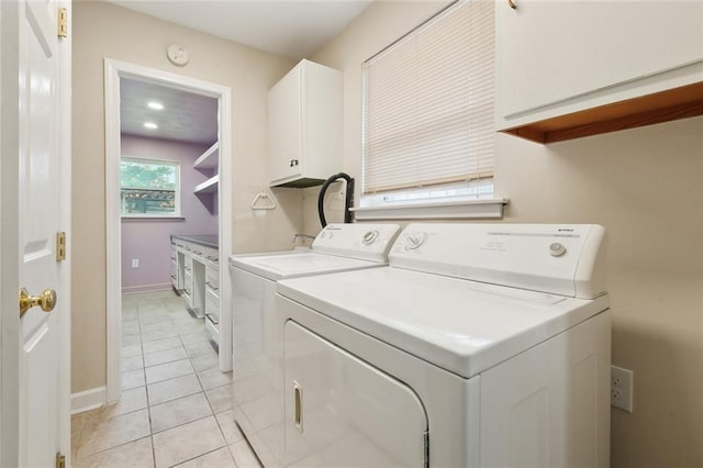 4912 Ithaca St, Metairie, LA 70006 - washroom with cabinet space, washer and dryer, light tile patterned flooring, and baseboards