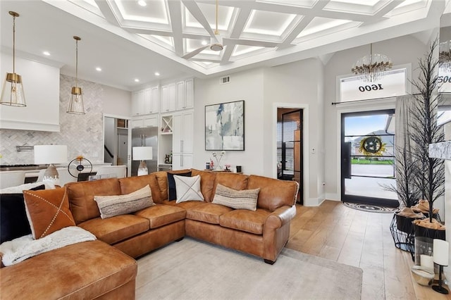 1600 Heatherwood Dr, Harvey, LA 70058 - living area with coffered ceiling, a towering ceiling, light wood finished floors, baseboards, and a chandelier
