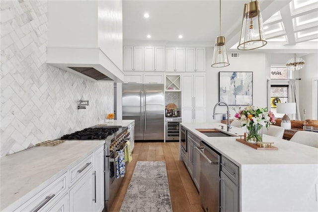 1600 Heatherwood Dr, Harvey, LA 70058 - kitchen with premium appliances, a sink, backsplash, custom exhaust hood, and white cabinets
