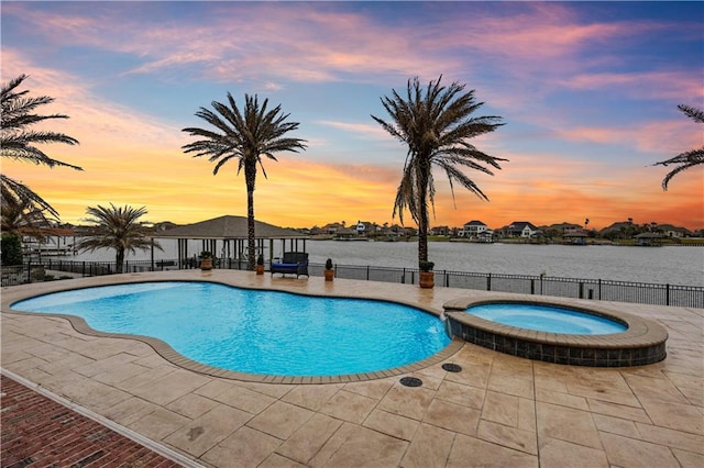 1125 Lakeshore Blvd, Slidell, LA 70461 - pool at dusk with a patio area, a pool with connected hot tub, and a water view