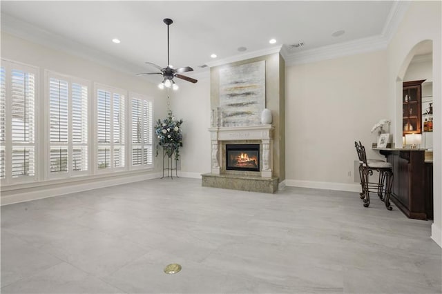 1125 Lakeshore Blvd, Slidell, LA 70461 - living area with crown molding, a glass covered fireplace, ceiling fan, arched walkways, and baseboards
