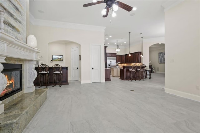 1125 Lakeshore Blvd, Slidell, LA 70461 - living room featuring arched walkways, ceiling fan, a fireplace, ornamental molding, and baseboards