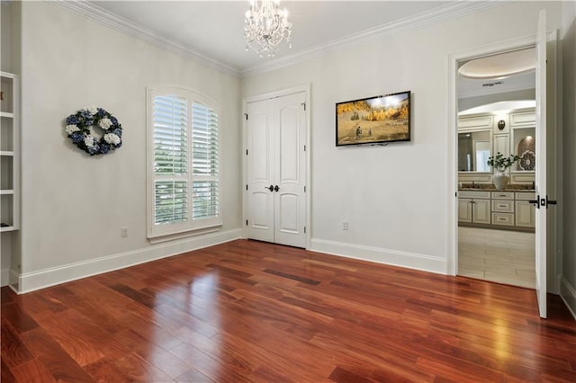 1125 Lakeshore Blvd, Slidell, LA 70461 - unfurnished bedroom featuring wood finished floors, a chandelier, ornamental molding, baseboards, and arched walkways