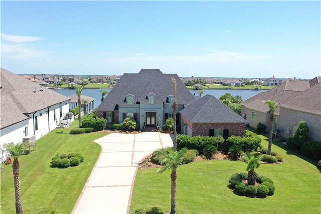 1125 Lakeshore Blvd, Slidell, LA 70461 - french country inspired facade featuring concrete driveway, an attached garage, a water view, and a front yard