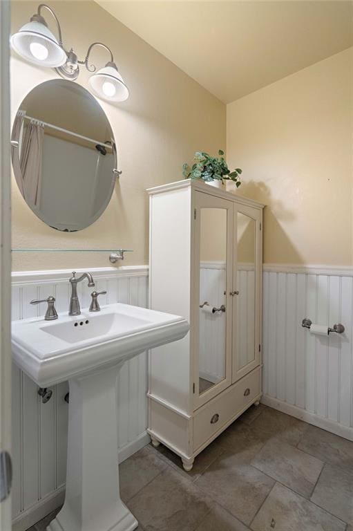 110 Willow Dr, Covington, LA 70433 - bathroom featuring wainscoting, a sink, and a decorative wall
