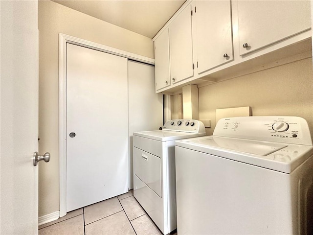 110 Willow Dr, Covington, LA 70433 - laundry area featuring washing machine and dryer, cabinet space, and light tile patterned floors