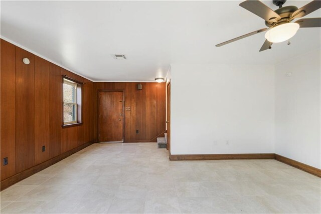 7356 Cameo St, New Orleans, LA 70124 - empty room with baseboards, wood walls, stairway, and ceiling fan