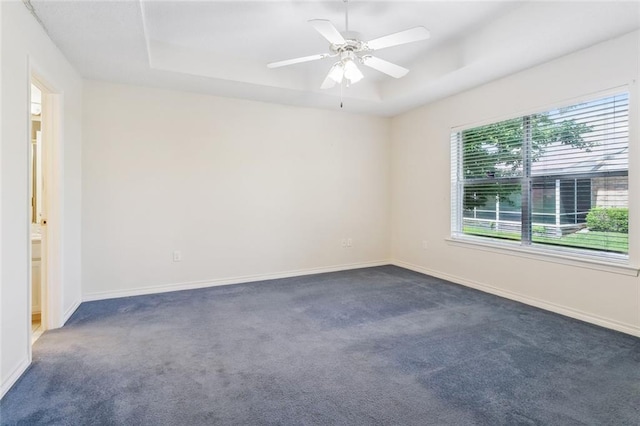 768 Wilkinson St, Mandeville, LA 70448 - unfurnished room featuring a tray ceiling, dark carpet, and baseboards