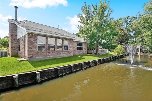 768 Wilkinson St, Mandeville, LA 70448 - rear view of property with brick siding, a water view, cooling unit, a chimney, and a lawn