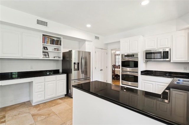 114 Kendrick Dr, Slidell, LA 70461 - kitchen with stainless steel appliances, built in study area, dark countertops, white cabinets, and recessed lighting