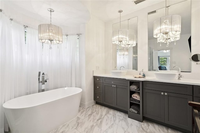 114 Kendrick Dr, Slidell, LA 70461 - full bathroom with a chandelier, a soaking tub, double vanity, and marble look tiles