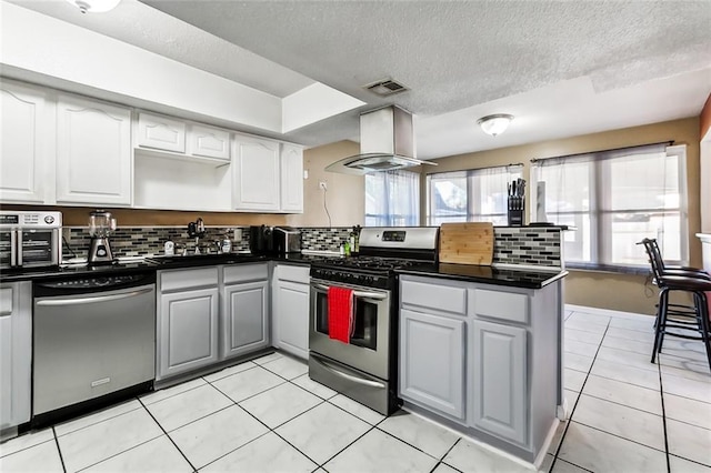 3500 Silver Maple Ct, New Orleans, LA 70131 - kitchen with stainless steel appliances, ventilation hood, dark countertops, a peninsula, and a textured ceiling