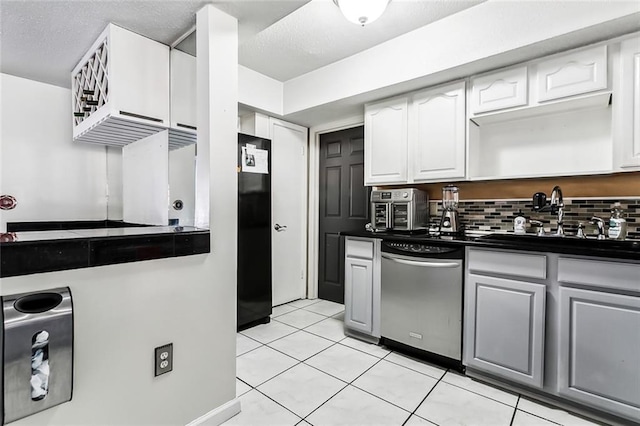 3500 Silver Maple Ct, New Orleans, LA 70131 - kitchen featuring stainless steel dishwasher, dark countertops, a sink, black fridge, and light tile patterned floors
