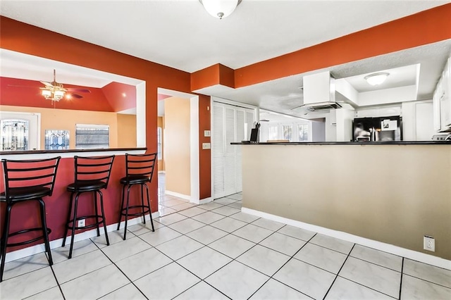 3500 Silver Maple Ct, New Orleans, LA 70131 - kitchen with stainless steel fridge, dark countertops, a peninsula, a ceiling fan, and baseboards