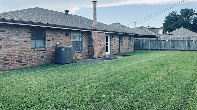 1217 Olde Oaks Dr, Westwego, LA 70094 - back of house featuring central air condition unit, roof with shingles, and brick siding