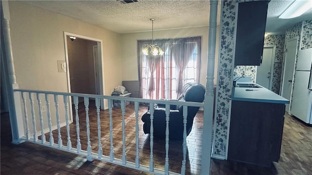 1217 Olde Oaks Dr, Westwego, LA 70094 - dining area featuring a chandelier, a textured ceiling, wood finished floors, and wallpapered walls