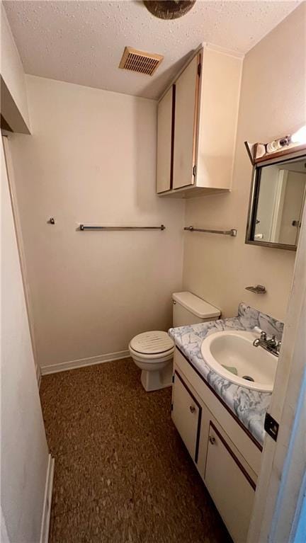 365 Cottage Ct, La Place, LA 70068 - bathroom with a textured ceiling, vanity, toilet, and baseboards