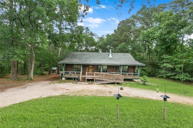138 Ned Ave, Slidell, LA 70460 - log cabin with a front lawn, a porch, log exterior, and view of wooded area