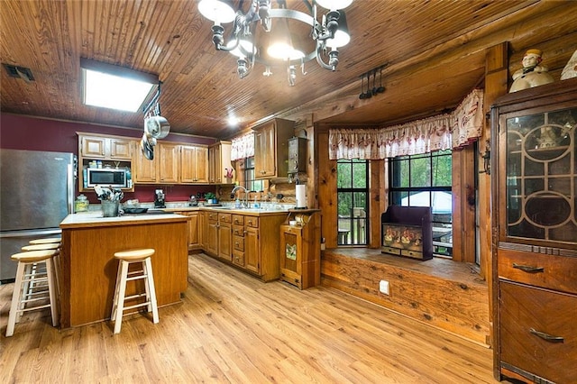138 Ned Ave, Slidell, LA 70460 - kitchen featuring appliances with stainless steel finishes, a sink, light countertops, light wood finished floors, and a chandelier