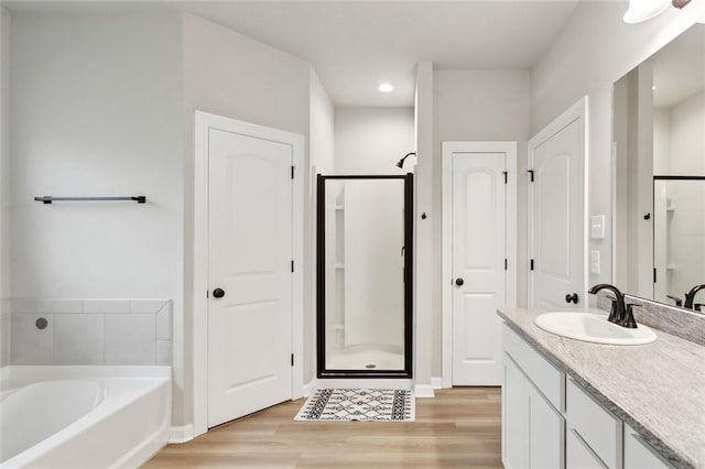 11557 Woodbluff Dr, Covington, LA 70433 - bathroom featuring a bath, wood finished floors, a shower stall, vanity, and recessed lighting