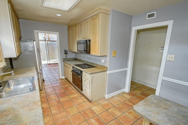 1032 7th St, New Orleans, LA 70115 - kitchen with black appliances, light countertops, light tile patterned floors, light brown cabinets, and recessed lighting