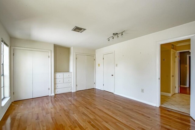 1032 7th St, New Orleans, LA 70115 - unfurnished bedroom with two closets and light wood finished floors