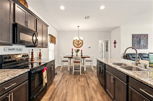 23406 Ruger Dr, Denham Springs, LA 70726 - kitchen with black appliances, a sink, dark brown cabinets, light wood-style floors, and a chandelier