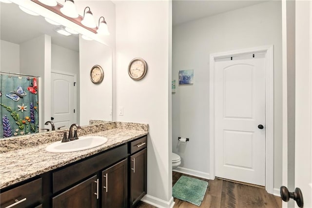 23406 Ruger Dr, Denham Springs, LA 70726 - bathroom with vanity, wood finished floors, toilet, and baseboards