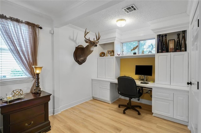 4633 Glendale St, Metairie, LA 70006 - office area with plenty of natural light, ornamental molding, light wood finished floors, built in desk, and a textured ceiling