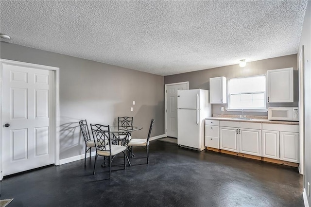 4633 Glendale St, Metairie, LA 70006 - dining area with concrete floors, a textured ceiling, and baseboards
