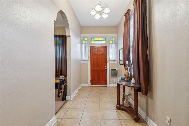 925 N Prieur St, New Orleans, LA 70116 - entryway featuring arched walkways, baseboards, light tile patterned floors, a chandelier, and a textured wall