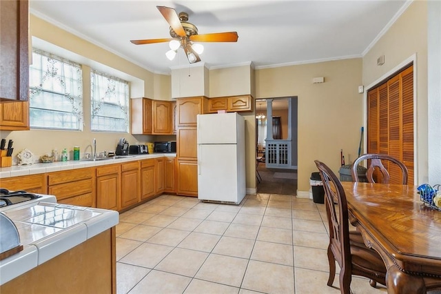 925 N Prieur St, New Orleans, LA 70116 - kitchen with freestanding refrigerator, a sink, tile countertops, black microwave, and a ceiling fan