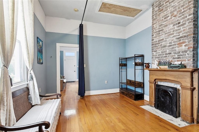324 Angela St, Arabi, LA 70032 - living area with light wood-type flooring, baseboards, and a fireplace with flush hearth