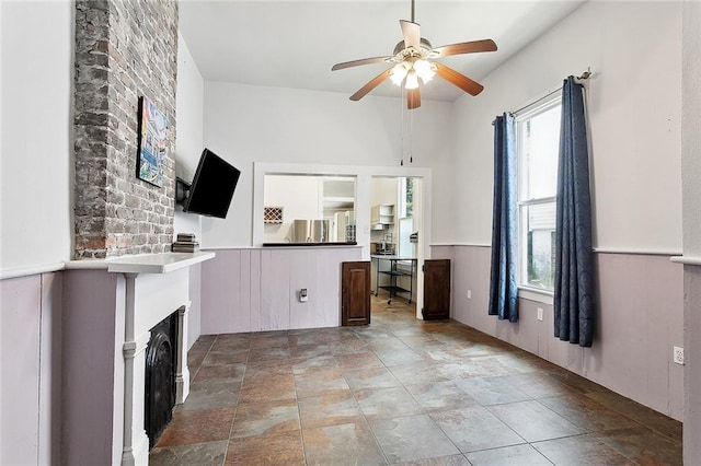 324 Angela St, Arabi, LA 70032 - unfurnished living room with healthy amount of natural light, ceiling fan, light stone finish floors, and a fireplace