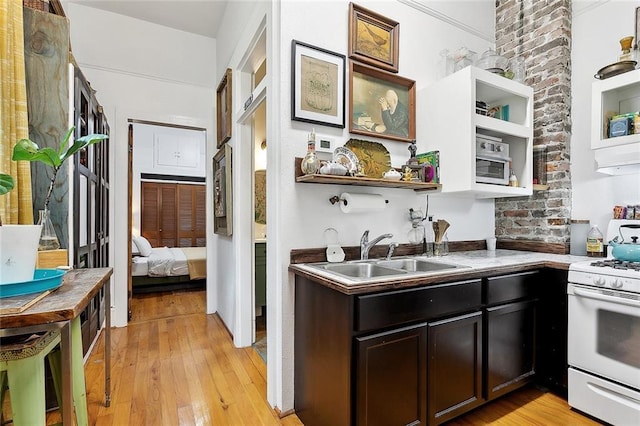 324 Angela St, Arabi, LA 70032 - kitchen with a sink, white gas stove, open shelves, and light wood-style floors