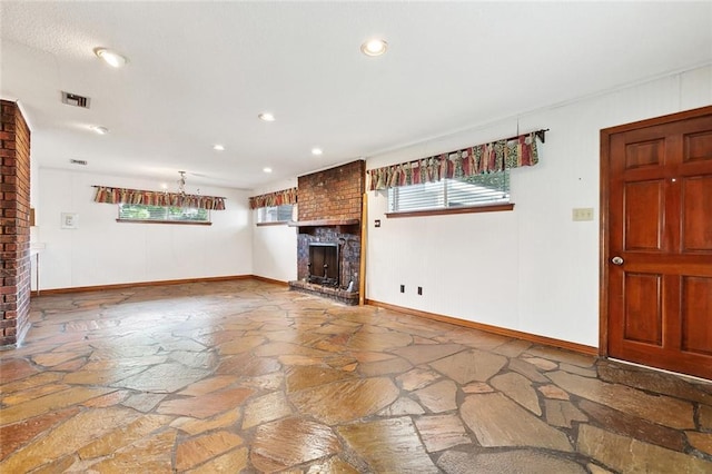 1500 Hudson St, Kenner, LA 70062 - unfurnished living room with a brick fireplace, stone flooring, baseboards, and recessed lighting