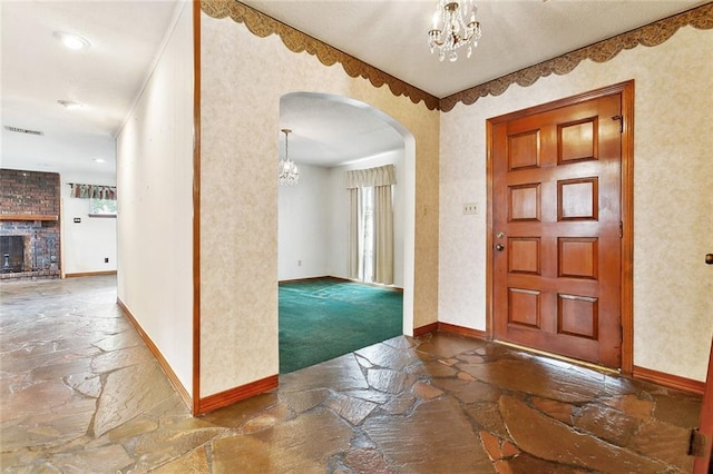 1500 Hudson St, Kenner, LA 70062 - entrance foyer featuring stone floors, a chandelier, baseboards, and arched walkways