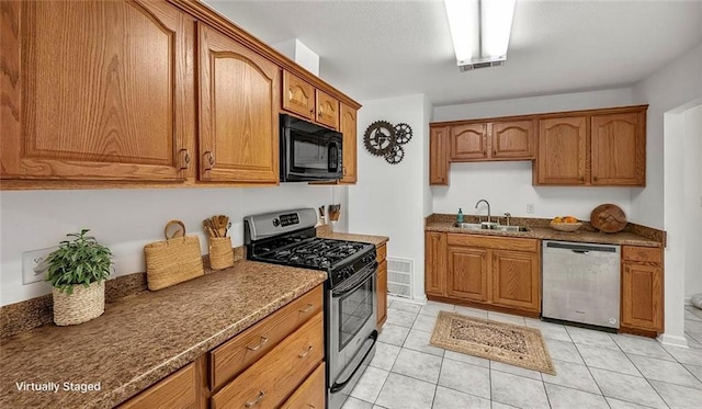 2112 Munster Blvd, Meraux, LA 70075 - kitchen with appliances with stainless steel finishes, a sink, brown cabinets, and light tile patterned flooring