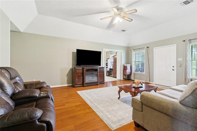 7045 River Rd, Waggaman, LA 70094 - living room featuring plenty of natural light, a ceiling fan, light wood-style floors, baseboards, and vaulted ceiling
